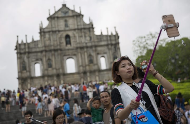 epa05292745 A woman takes a selfie in front of the Saint Paul's ruins in the historic center of the city in Macau, China, 06 May 2016(issued 07 May 2016). The ruins dates back to the 16th century and were listed in 2005 as part of the Historic Centre of Macau, a UNESCO World Heritage Site. Macau, once a popular destination for mainland gamblers, launched in April an ambitious five-year plan to increase tourism revenues and to reduce the economy’s reliance on gaming.  EPA/JEROME FAVRE